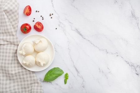 Mozzarella with tomatoes, butter and basil on a white background