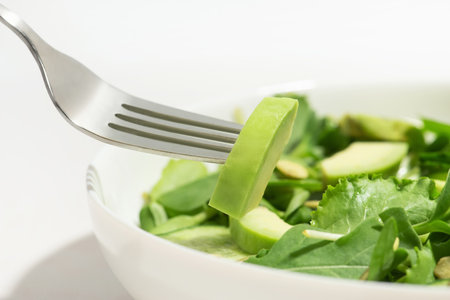 Macro photo of salad with avocado on a forkの写真素材