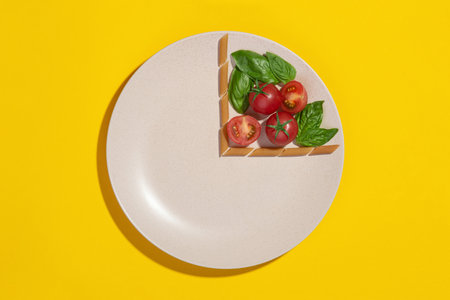plate with ingredients for pasta with tomatoes and basil in the form of a clock on a yellow...