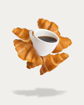 Flying croissants with a mug of coffee on a white background. breakfast concept. bakeryの写真素材