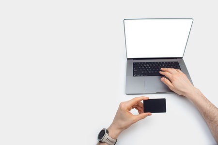 men's hands with a map and a phone on the background of a laptop. Online delivery, payment.の写真素材