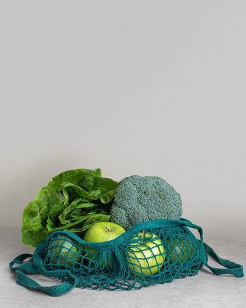 Green vegetables and fruits in an avalka on the kitchen table.zero waste packagingの写真素材