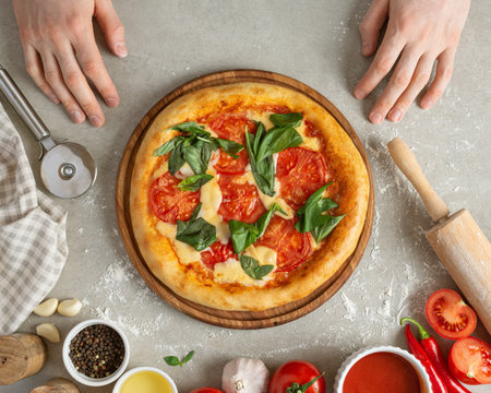 The process of making margarita pizza. Male hands, top view. Tomato paste with cheese.の素材 [FY310198164680]