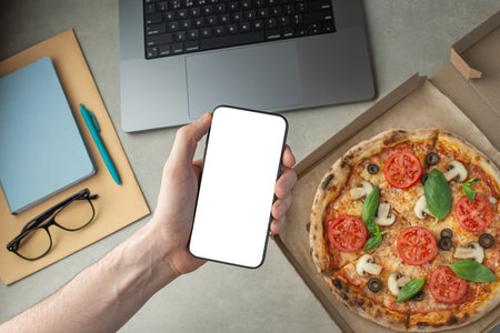 A man works and eats pizza, top view, hands on the desktop. Pizza delivery.の写真素材