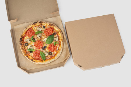 Pizza margherita with tomatoes and mushrooms on a white isolated backgroundの写真素材