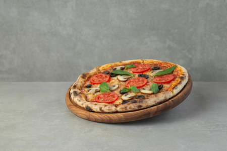 Pizza margherita with tomatoes and mushrooms on a gray background, top viewの写真素材