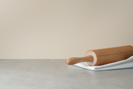 white kitchen towel and rolling pin on gray background, side viewの写真素材