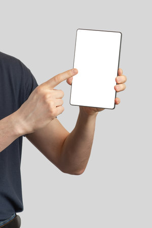 European man with a tablet in his hands on an isolated gray backgroundの写真素材