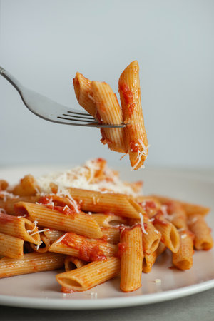 Pasta on a fork with tomatoes and cheeseの写真素材