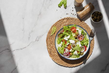 Greek salad with vegetables and cheese on a gray tableの写真素材