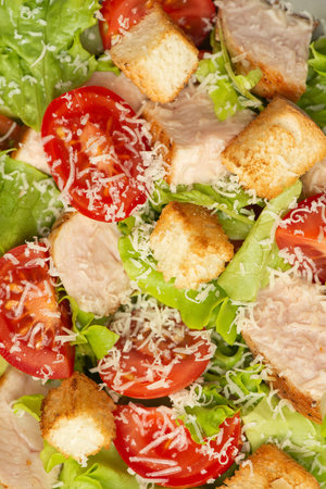 Vegetable salad with chicken and cheese on a gray table. Caesar salad in a gray plate.の写真素材