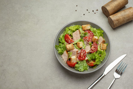 Vegetable salad with chicken and cheese on a gray table. Caesar salad in a gray plate.の写真素材
