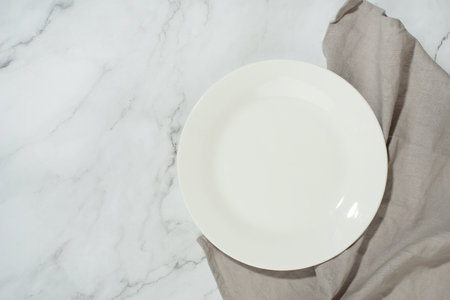 Empty white plate on gray marble table, culinary backgroundの写真素材