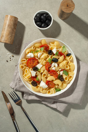 Pasta salad with dried tomatoes, cheese and olivesの写真素材