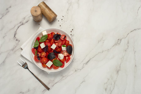 Salad with tomatoes, feta and basil on a gray backgroundの写真素材