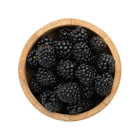 blackberry berries in a wooden plate on a white background