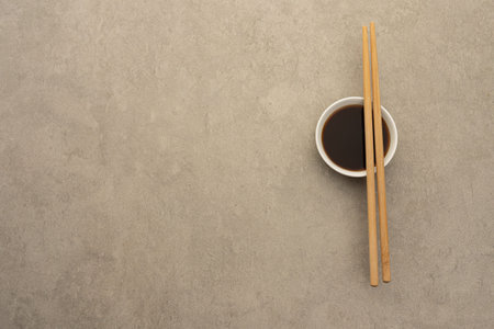 Gray neutral background with gray sauce bowl and soy sauce, with bamboo chopsticksの写真素材