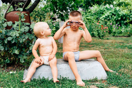 brother and sister with blue eyes play together in the countryside in nature in summerの写真素材