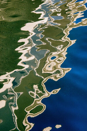 abstract blue and green water reflections off dock in Maine