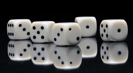 White gambling dices with black dots on a mirrorの写真素材