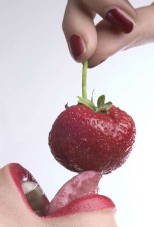 red lips is eating red strawberryの写真素材