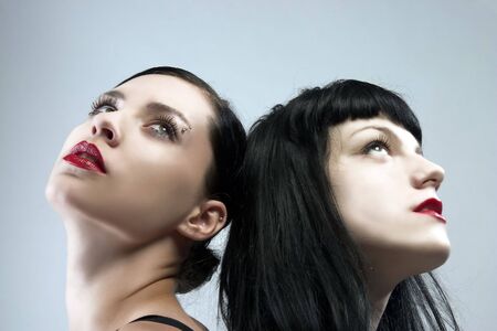 two female portraits with black hair and red lipsの写真素材