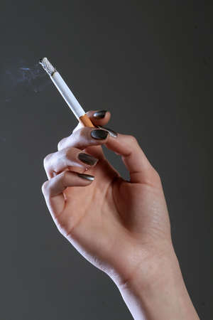 a photo of a burning cigarette on gray backgroundの写真素材