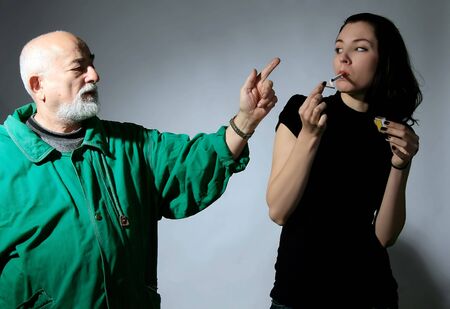 a senior man is telling girl to stop smokingの写真素材