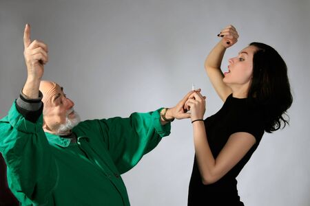 a senior man and young girl are fightingの写真素材