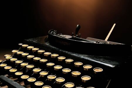 an old typewriter on orange backgroundの写真素材