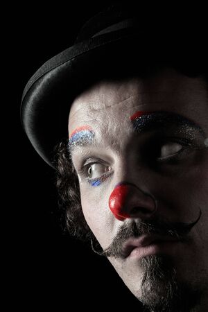 a portrait of a thoughtful clown on blackの写真素材
