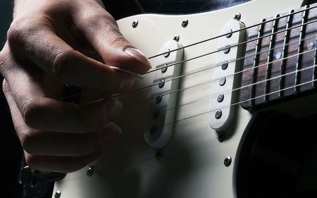 man is playing electric guitar on blue