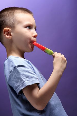 photo of a boy eating color ice creamの写真素材