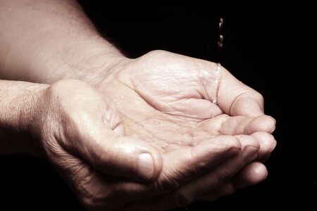 photo of an old male hands with waterの写真素材