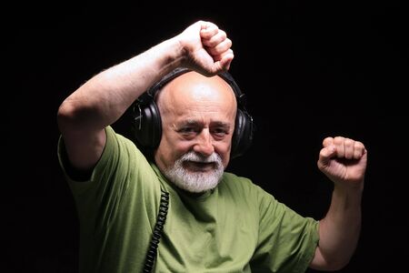 photo af a senior with headphones listening musicの写真素材