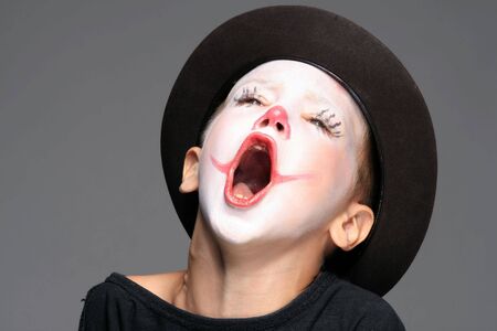 portrait of make up clown boy with red noseの写真素材