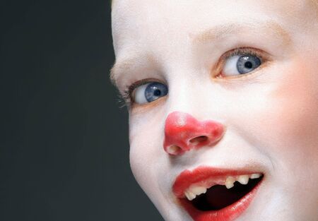 portrait of make up clown boy with red noseの写真素材