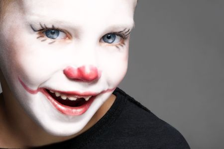 portrait of make up clown boy with red nose