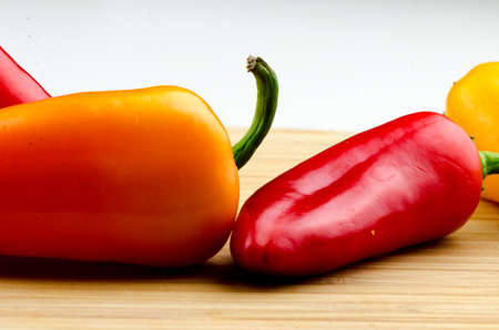 A mix of colored peppers on the cutting board.の写真素材