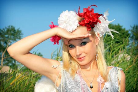 Young girl with flowers in her hair on nature