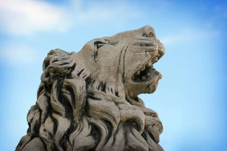 Head of stone lion statue on background blue skyの写真素材
