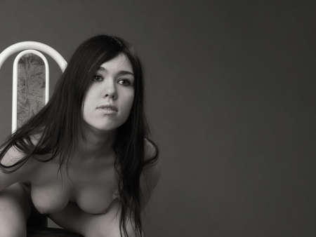 Sexy denuded girl, brunette on gray backgroundの写真素材