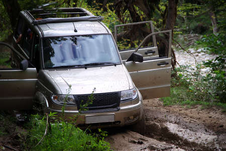 Russian off-road car on a dirty road in the forest