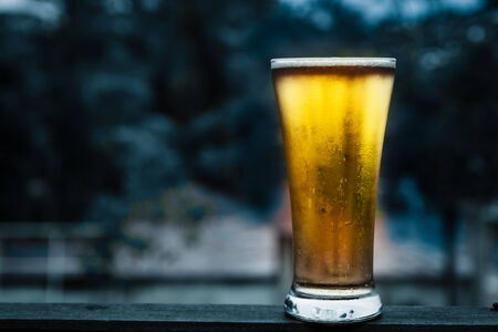 Glass beer on wood background with copyspace
