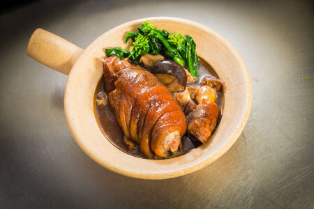 Steam pork leg with vegetable on clay potの写真素材