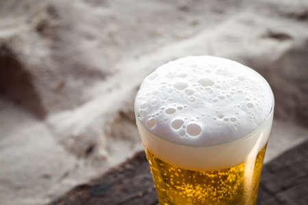 Beer close-up in glass on sand beachの写真素材