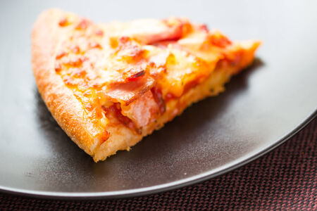 Slice of tasty pizza on a plateの写真素材