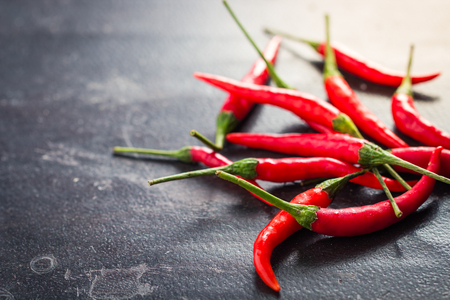 Red hot chili peppers on old wooden tableの写真素材
