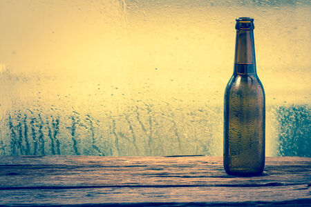 Beer bottle on  wooden backgroundの写真素材
