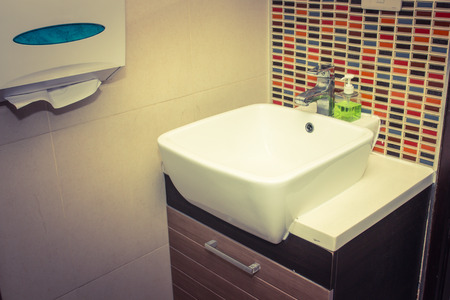 detail of a modern bathroom with sink and accessories, bathroom cabinet and brown bathroom tilesの写真素材